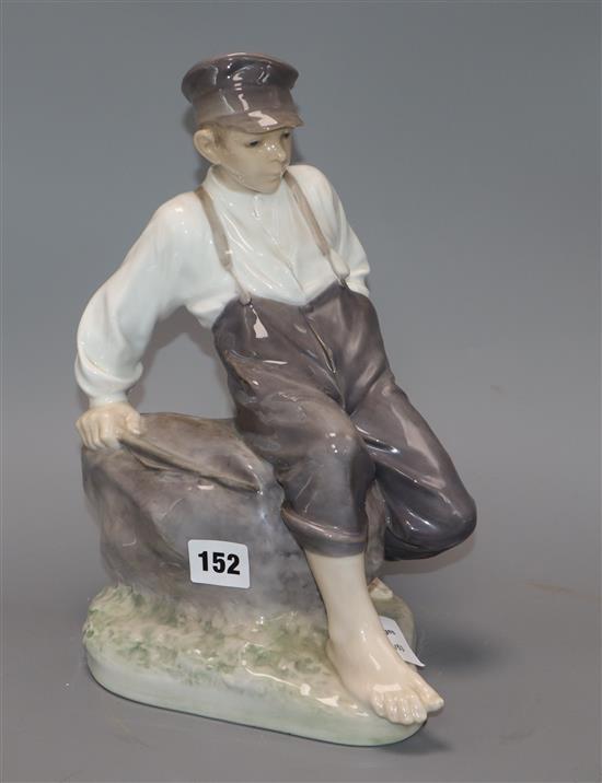 A Royal Copenhagen figure of a seated boy, modelled by Christian Thomsen, number 1659, 30cm height 30cm